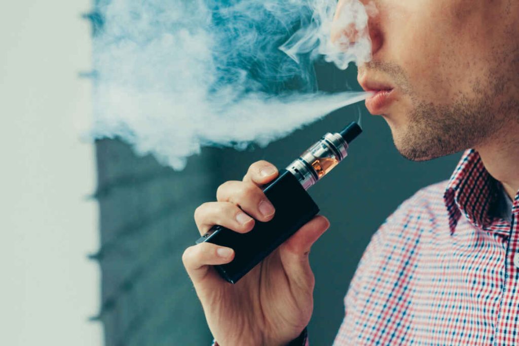 Close up on a man exhaling vapor from an electronic cigarette